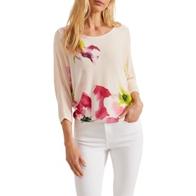 Model wearing Phase Eight Erika Placement Floral Sweater in multi, pink floral print, batwing sleeves, styled with white jeans
