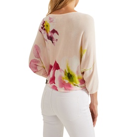 Model wearing Phase Eight Erika Placement Floral Sweater in blush with pink floral print, batwing sleeves, styled with white trousers