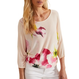 Model wearing Phase Eight Erika Placement Floral Sweater in multi, with pink floral print, batwing sleeves, styled with white trousers