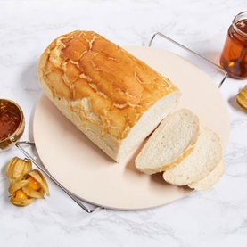 Zyliss Ceramic Baking Stone in natural, shown with sliced white bread loaf, styled with jam jar and physalis on marble surface