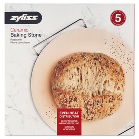Zyliss Ceramic Baking Stone in natural, round with metal handle, shown in packaging with freshly baked seeded bread loaf on top