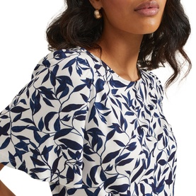 Model wearing Phase Eight Nayana Leaf Print Blouse in blue, close-up showing round neckline, flutter sleeves, and navy leaf print on cream ground