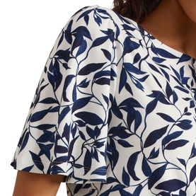 Model wearing Phase Eight Nayana Leaf Print Blouse in blue and white, showing flutter sleeve and all-over leaf print detail at the shoulder