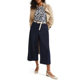 Model wearing Phase Eight Nayana Leaf Print Blouse in blue with navy wide-leg culottes, beige jacket and flat shoes