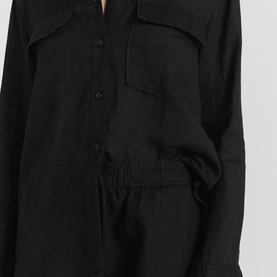 Model wearing Twist & Tango Melody Relaxed Fit Linen Shorts in black with elasticated drawstring waist, styled with a matching black linen shirt