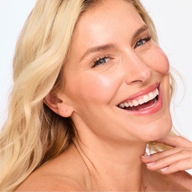 Model wearing Trinny London BFF De-Stress Tinted Serum in shade Claire, showing natural, glowing complexion finish on fair skin