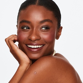 Model with Trinny London Lip2Cheek Colour in Munchkin, showing a natural flush on cheeks and radiant skin
