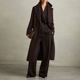Model wearing Reiss Lucia Double-Breasted Coat in brown with oversized lapels and self-fabric belt