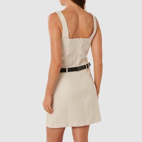 Model wearing Forever New Charlie Belted Mini Dress in cream linen with wide straps, square neckline and black faux-leather belt. Back view