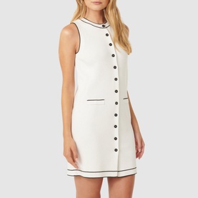 Model wearing Forever New Molly Tipped Mini Dress in white with black contrast tipping, button placket, round neckline, and front welt pockets
