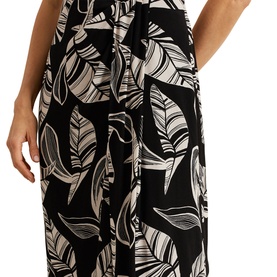 Model wearing Phase Eight Ayana Printed Skirt in black with white leaf print, midi length flared silhouette with tie waist detail