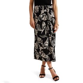Model wearing Phase Eight Ayana Printed Skirt in black with white leaf print, midi length, flared silhouette, styled with black heeled sandals