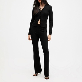 Model wearing All Saints Cruz Ribbed Cardigan in black, open-front V-neck style with long sleeves, paired with black flared trousers and heeled mules