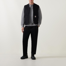 Model wearing Carhartt Logo Vest Gilet in black with grey sweatshirt, black trousers and black chunky trainers