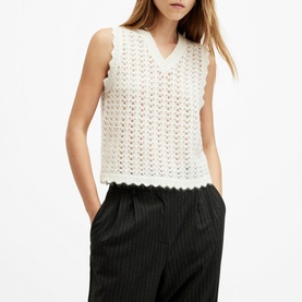 Model wearing All Saints Vivian Open-Stitch Knitted Vest in white with scalloped trim and V-neck, styled with black pinstripe trousers