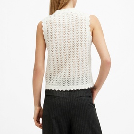 Model wearing All Saints Vivian Open-Stitch Knitted Vest in white, showing back view with scalloped-edge trim and open-stitch detail