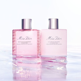 Dior Miss Dior Indulgent Shower Gel with Rose Water in pink bottle, shown alongside matching Miss Dior body lotion on reflective surface