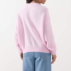 Model wearing AMERICAN VINTAGE Vitow Oversized Sweater in Dragee Chine pink, back view, with light blue jeans. Relaxed fit, ribbed hem visible.