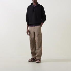 Model wearing Hugo Logo Half-Zip Sweatshirt in black with high neckline, styled with beige cargo trousers and brown sandals