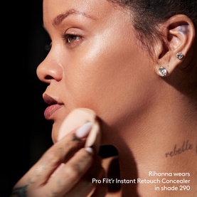 Model wearing FENTY Pro Filt'r Instant Retouch Concealer in shade 290, applied with a sponge applicator