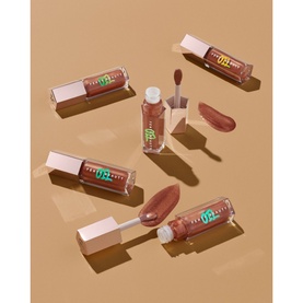 Fenty Gloss Bomb Oil in Coppa Cookie, 9ml, shown as a set of four lip oils with applicator wands and swatches in warm nude tones