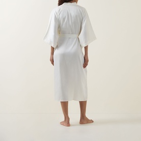 Model wearing Gingerlilly Henrietta Satin Robe in ivory, shown from behind, mid-length with wide sleeves and self-fabric belt.