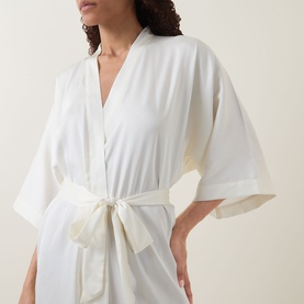 Model wearing Gingerlilly Henrietta Satin Robe in ivory, wrap style with self-fabric belt tied at waist and wide mid-length sleeves