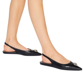 Model wearing Kurt Geiger London Belgravia Slingback Pointed Toe Flats in black leather with gold eagle head detail and elasticated slingback strap