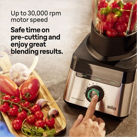 Braun Powerblend 7 black blender in use, filled with tomatoes, with fresh vegetables on a chopping board alongside