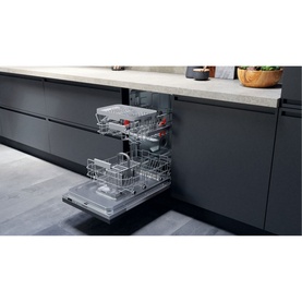 Hotpoint Built-In Slimline Dishwasher 9 Place 54cm open in dark kitchen cabinetry, showing three loaded wire baskets