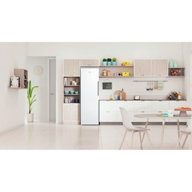 Indesit Freestanding 60cm NoFrost Freezer 259L in white, styled in a bright modern kitchen with open shelving and dining area