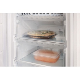 Indesit Freestanding 60cm NoFrost Freezer 259L interior showing adjustable shelves with stored food containers and a pizza dish