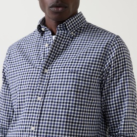 Model wearing Gant Embroidered Logo Gingham Shirt in navy, featuring button-down collar and chest pocket, close-up detail view