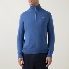 Model wearing Gant Shield Half-Zip Logo Sweater in blue, featuring funnel neckline, half-zip fastening and small logo embroidery