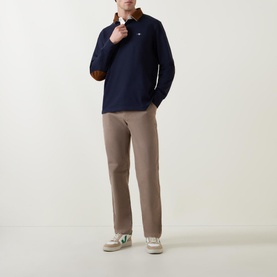 Model wearing Gant Corduroy Collared Rugby Shirt in navy with tan corduroy collar and elbow patches, styled with taupe trousers and trainers