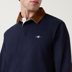 Model wearing Gant Corduroy Collared Rugby Shirt in navy, featuring tan corduroy collar and embroidered logo at chest