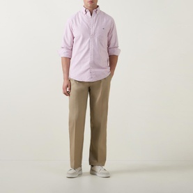 Model wearing Gant Shield Striped Casual Shirt in pink, long sleeves, button-down collar, styled with tan chinos and white trainers
