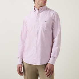 Model wearing Gant Shield Striped Casual Shirt in pink stripe, long sleeve, button-down collar, chest pocket with logo detail
