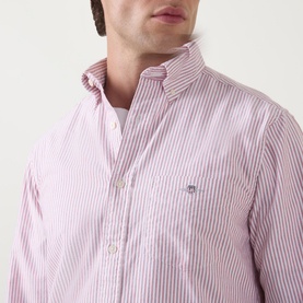 Model wearing Gant Shield Striped Casual Shirt in pink and white stripe, with logo detail visible on chest, styled over white crew neck tee