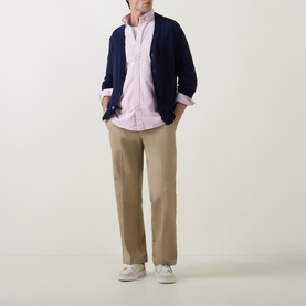 Model wearing Gant Shield Striped Casual Shirt in pink, styled with navy cardigan, beige chinos and white trainers