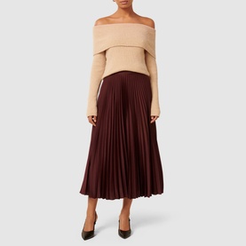 Model wearing Forever New Estelle High-Rise Pleated Skirt in burgundy satin with beige off-shoulder knit top and black heels