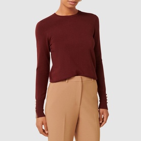 Model wearing Forever New Katie Split-Cuff Sweater in burgundy, long sleeves with split cuffs, crew neckline, styled with camel trousers
