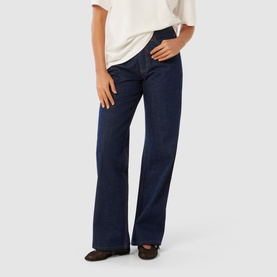 Model wearing Forever New Sky High-Rise Straight Leg Jeans in blue dark wash denim, styled with a white tee and brown flat shoes