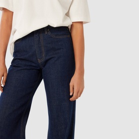 Model wearing Forever New Sky High-Rise Straight Leg Jeans in dark blue wash, straight-leg cut with contrast stitching, styled with a white top