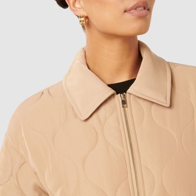 Model wearing Forever New Jacinta Quilted Jacket in brown, showing classic collar, front zip fastening and subtle quilted pattern detail