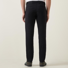 Model wearing Hugo Boss Orange Slim-Leg Chinos in black, rear view showing slim fit, belt loops, and rear welt pockets