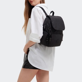 Model carrying Kipling City Zip S Backpack in black printed fabric, flap with zip fastening, silver-tone hardware