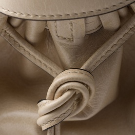 Prada Accessories Bonnie Large Leather Handbag in cream, close-up of knotted leather strap and buckle detailing with visible stitching
