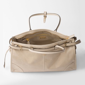 Prada Accessories Bonnie Large Leather Handbag in cream, open top view showing gold-tone hardware, zip fastening, and logo-print nylon interior
