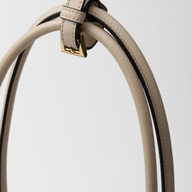 Prada Accessories Bonnie Large Leather Handbag in cream, close-up of dual top handles with gold-tone buckle strap detailing